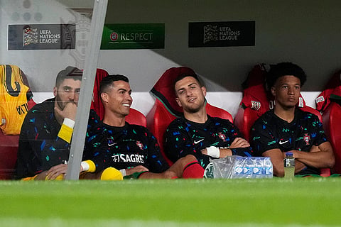 2024–25 UEFA Nations League, Portugal vs Scotland: Portugal's Cristiano Ronaldo, second from left, smiles as he sits on the bench 